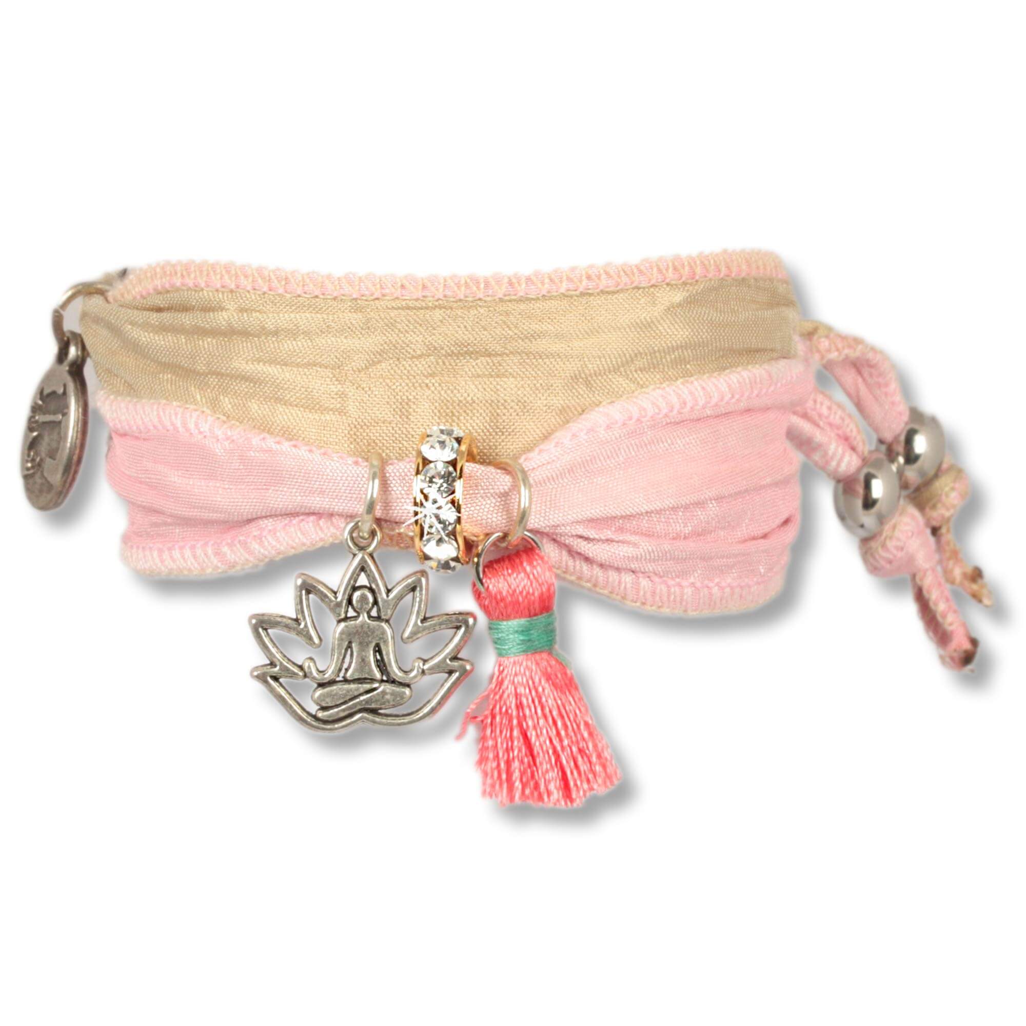  Handmade fabric bracelet made from saris and silk fabrics in Rosé, natural colours and gold. Decorated with a metal lotus flower depicting a meditating Buddha, a yellow silk tassel and a rondel set with Czech crystals. Manufacturer: Anisch de la Cara. Un