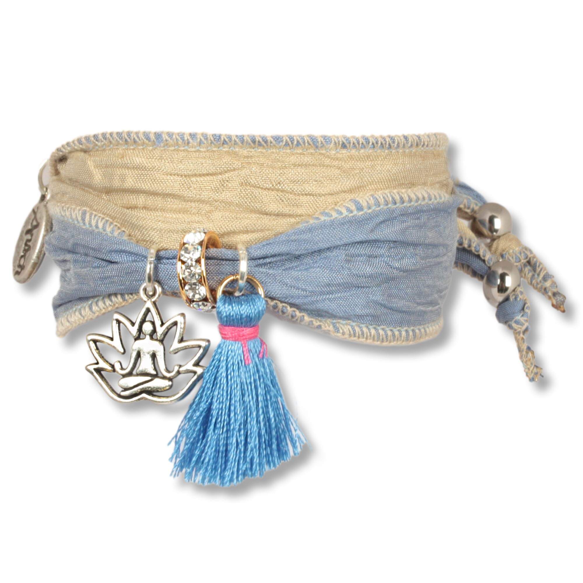 Handgefertigtes Stoffarmband aus Saris und Seidenstoffen in Blau, Naturfarben. Verziert mit einer metallenen Lotusblume, die einen meditierenden Buddha zeigt, einer blauen Seidenquaste, einem Rondell besetzt mit tschechischen Kristallen. Hersteller: Anisc